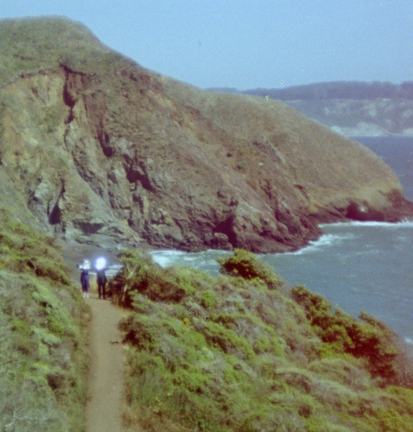 still from emily chao's film light signal showing two small figures on a california coastal cliff